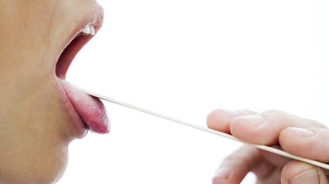 woman's throat checked with a tongue depressor