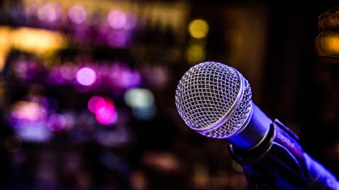 Microphone set up with lights for a comedy music show in a bar.